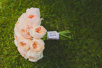 Image showing wedding bouquet of the bride at the grass.