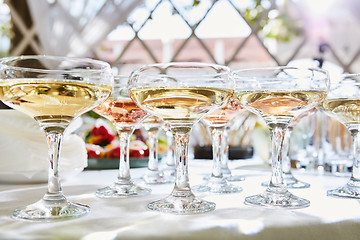 Image showing Row of glasses filled with champagne are lined up ready to be served.