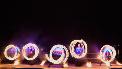 Image showing Artists juggling with burning poi\'s at fire performance.