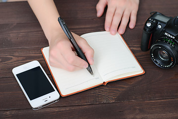 Image showing Top view of a hands with pen and notepad