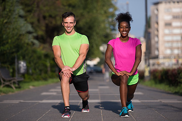 Image showing jogging couple warming up and stretching in the city