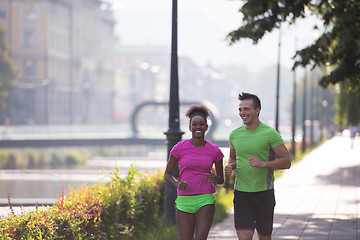 Image showing young multiethnic couple jogging in the city