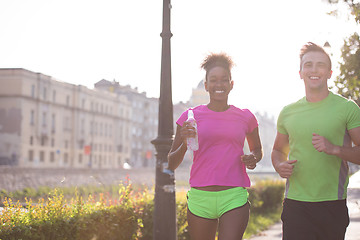 Image showing young multiethnic couple jogging in the city