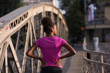 Image showing african american woman running across the bridge