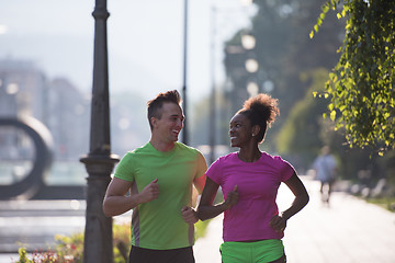 Image showing young multiethnic couple jogging in the city