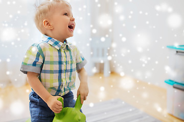 Image showing happy baby boy playing with ride-on toy at home