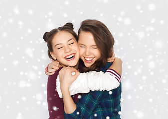 Image showing happy smiling teenage girls hugging over snow