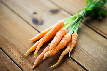 Image showing close up of carrot bunch on wooden table