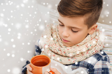 Image showing close up of ill boy with flu drinking tea at home