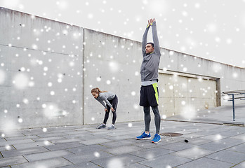 Image showing couple with jumping ropes stretching outdoors