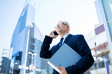 Image showing senior businessman calling on smartphone in city