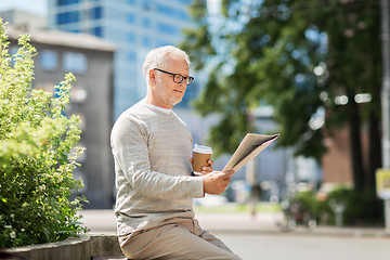 Image showing senior man reading newspaper and drinking coffee