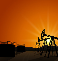 Image showing Oil pump jack for petroleum and reserve tanks on sunrise backgro