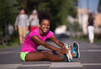 Image showing sporty young african american woman stretching outdoors