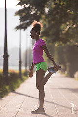 Image showing Black woman doing warming up and stretching