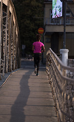 Image showing african american woman running across the bridge