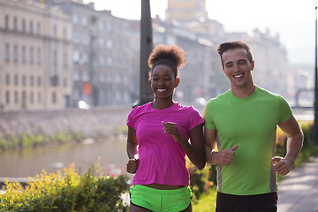 Image showing young multiethnic couple jogging in the city