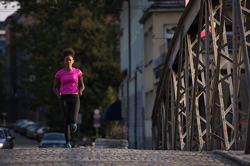 Image showing african american woman running across the bridge