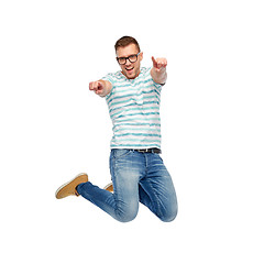 Image showing happy man jumping and pointing fingers to you
