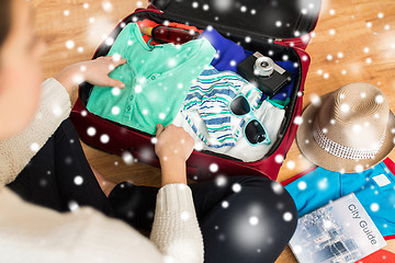 Image showing close up of woman packing travel bag for vacation