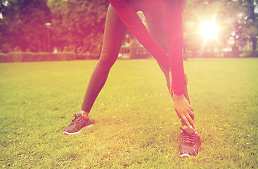 Image showing close up of woman stretching leg outdoors