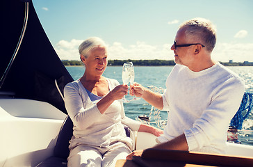 Image showing senior couple clinking glasses on boat or yacht