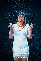 Image showing The young girl standing under running water