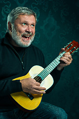 Image showing Studio portrait of senior man with guitar.