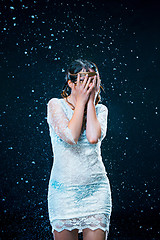 Image showing The young girl standing under running water