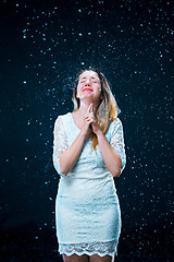 Image showing The young girl standing under running water