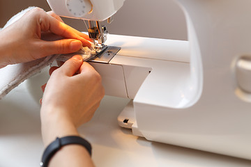 Image showing Girl makes stitch on sewing-machine