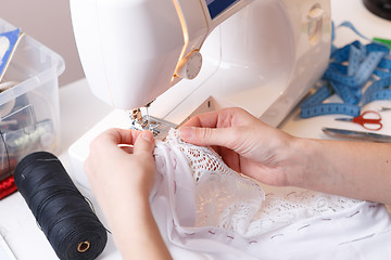 Image showing Girl makes stitch on sewing-machine