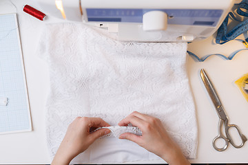 Image showing Seamstress prepares fabric for sewing