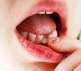 Image showing Closeup of finger feeling a lose tooth in a little girls mouth