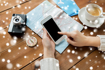 Image showing close up of traveler hands with smartphone and map