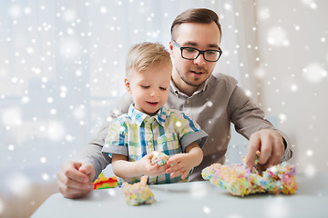 Image showing father and son playing with ball clay at home