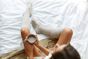 Image showing close up of woman with cocoa cup in bed at home