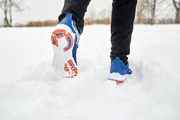 Image showing close up of feet running along snowy winter road