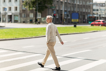 Image showing senior man walking along city crosswalk