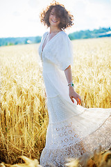 Image showing woman in fashionable white dress dancing in a golden field