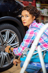 Image showing woman pulls the wheel bolts