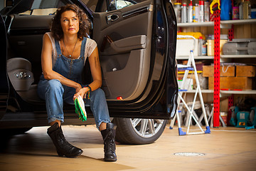 Image showing Portrait of a handsome mechanic in blue overalls on the threshol