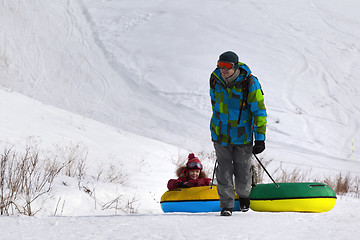 Image showing Father and daughter with snow tube at ski resort