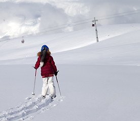 Image showing Girl on skis in off-piste slope with new fallen snow at nice day