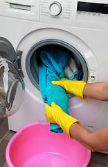 Image showing woman hands in gloves holding clothes