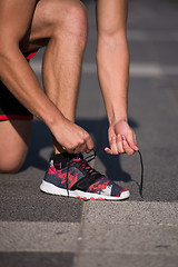 Image showing Young athlete, runner tie shoelaces in shoes