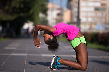 Image showing sporty young african american woman stretching outdoors