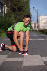 Image showing Young athlete, runner tie shoelaces in shoes