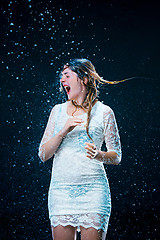 Image showing The young girl standing under running water