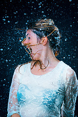 Image showing The young girl standing under running water